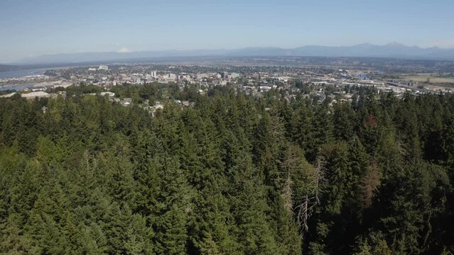 Revealing aerial shot of downtown Everett, Washington with scenic mountain landscape in distance - 4K Drone