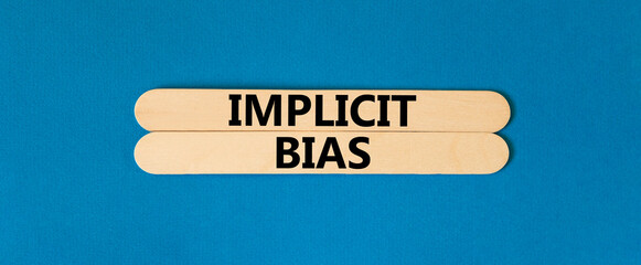 Implicit bias symbol. Concept words Implicit bias on wooden sticks. Beautiful blue table blue...