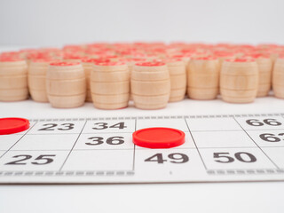 Board game bingo. Wooden barrels with lotto numbers, playing cards for the game. Close-up.