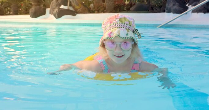 happy child in swimming pool with inflatable ring at resort hotel water park