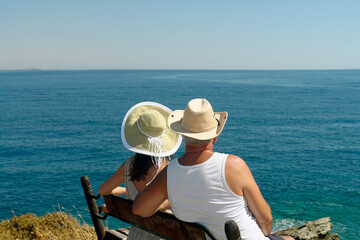 Sea view of a couple sitting on seat - 581228910