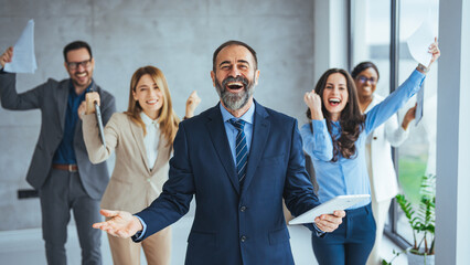 Obraz premium Business team celebrating a triumph with arms up. Celebrate to business success with colleagues. Business celebration party with co-worker partner in business marketing team