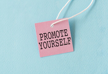 Promote Yourself text quote on a pink card, Business Concept on Blue Background.