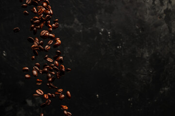 Roasted coffee beans falling on black background, Concept for coffee product advertising, Selective focus, place for text