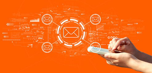 Email concept with person using a smartphone on a orange background