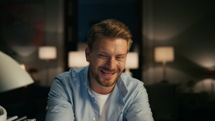 Obraz premium Overjoyed guy laughing comedy at evening zoom on. Man receiving funny message