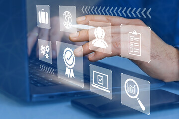 Businessman works on laptop with marks of highest quality of service, guarantees of company product...