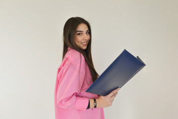 Happy young woman holding a blue folder at the office