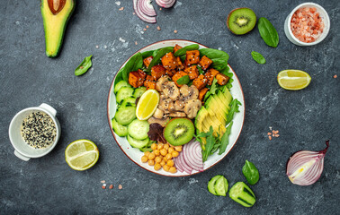 Healthy vegetable lunch in a Buddha bowl with tofu, avocado, chickpeas, cucumber and mushrooms, banner, menu, recipe place for text, top view