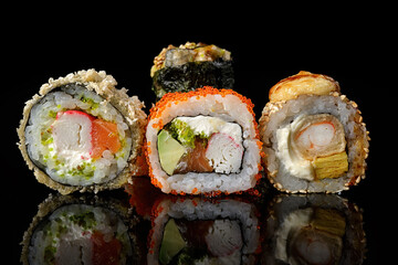 Sushi rolls of different types on a black background