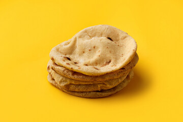 Egyptian bread Aish Baladi on. A lot of fresh bread lies on the yellow table