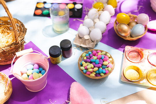 Close up of selection of colorful easter eggs and paints on table
