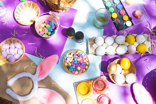 Close up of selection of colorful easter eggs and paints on table