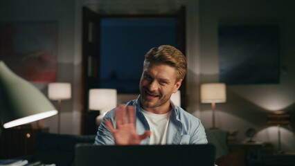 Fototapeta premium Positive guy greeting laptop at home closeup. Man confused of running woman
