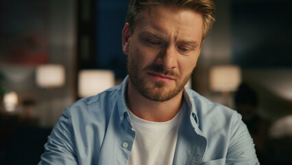 Obraz premium Closeup serious guy ending call at evening flat. Man watching wife rejoicing