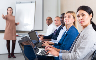 Fototapeta premium Side view of a group of businessmen undergoing training under the guidance of a teacher