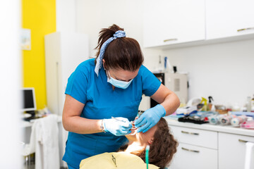 Dentist appointment at a dental clinic, placing braces locks on the teeth and pulling the archwire to fix it