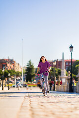 Naklejka premium sustainability eco transport lifestyle. uruguayan mid latina woman ride a bike outside in the city