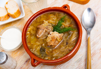 Soup of cabbage with boiled vegetables and pork broth, served in plate. High quality photo