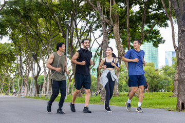Group of Man and woman friends in sportswear jogging exercise together at public park in the...