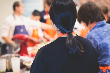 Group of children in a cooking class, kids preparing asian style food in the kitchen together, kids in aprons learn cooking on master class, chef uniform, hands in gloves