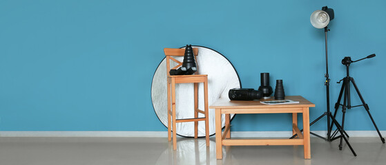 Wooden table and chair with different modern equipment of photographer in studio. Banner for design