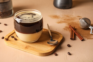 Wooden board with glass of tasty Cafe Bombon on color background