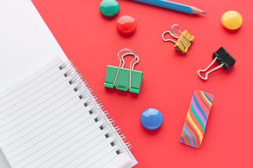 Set of stationery with binder clips on red background