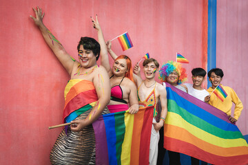 Fototapeta premium Happy Asian young friends holding rainbow flag celebrating gay pride festival - LGBTQ community concept