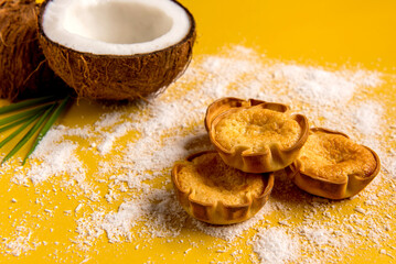 Coconut and coconut candy (cocadinha) on wooden background