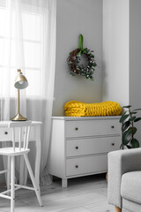 Interior of living room with Easter wreath and drawers