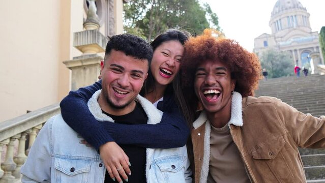 Group of three multiracial young friends having fun and smiling looking at camera. Front view of happy multiethnic people with cheerful attitude. Life style concept. Slow motion. High quality 4k