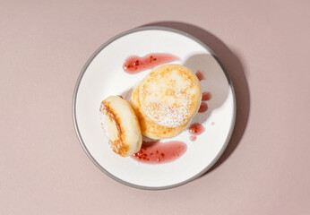 Plate with tasty cottage cheese pancakes and strawberry jam on color background