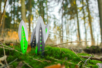  metal throwing knives set in green moss on sunny pine forest background.Outdoor sports.Throwing...
