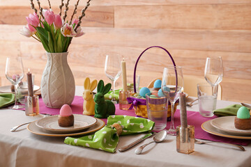 Beautiful Easter table setting with flowers and eggs in dining room