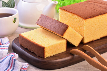 Castella (kasutera) - Delicious sliced honey sponge cake on wooden plate - obrazy, fototapety, plakaty