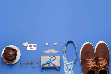 Composition with male accessories, muffin and gift for Father's Day celebration on blue background