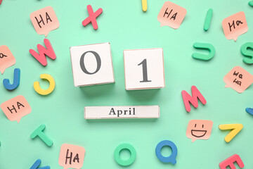 Date of April Fool's Day with letters and sticky papers on color background
