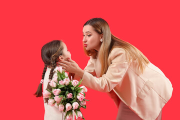 Cute little girl with tulips and her mother on red background