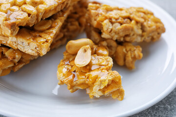 Delicious peanut kozinaki bars on white plate, closeup