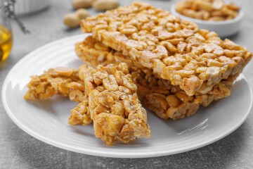 Delicious peanut kozinaki bars on white plate, closeup