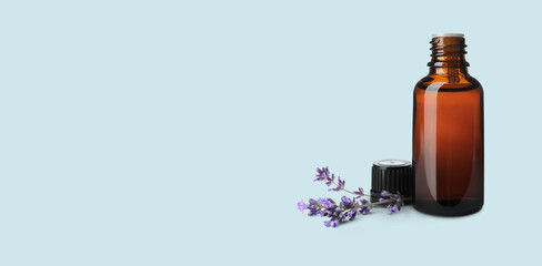 Bottle of lavender essential oil and flowers on pale light blue background, space for text. Banner design