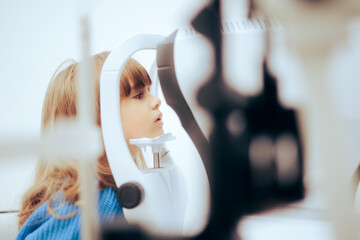 Toddler Girl During Eye Examination with a Slit Lamp Microscope. Little patient having her retina check with a biomicroscope instrument