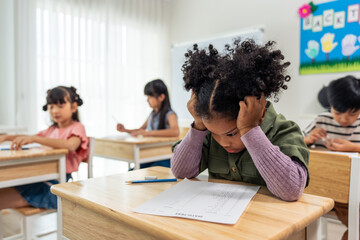 African American black girl student doing an exam at elementary school.  - Powered by Adobe