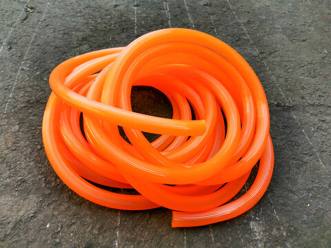 Image of rubber hose coiled on the ground.