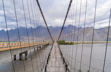Obraz premium A bridge in Karakoram high mountain hills. Nature landscape background, Skardu-Gilgit, Pakistan. Travel on holiday vacation.