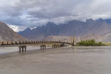 Zelfklevend Fotobehang A bridge in Karakoram high mountain hills. Nature landscape background, Skardu-Gilgit, Pakistan. Travel on holiday vacation. © tampatra