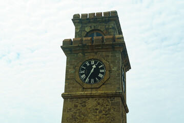 Old clock tower with roman numerals against the sky