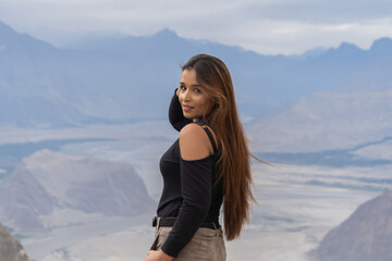 A Pakistani woman tourist travel in Karakoram high mountain hills. Nature landscape background, Skardu-Gilgit, Pakistan. Travel on holiday vacation. People lifestyle.