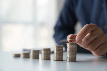 Businessmen, retirees, modern youths build their fortunes stacking coins on top of the highest row. Saving money for business growth. Investment. Savings. Concept of saving money for investment.